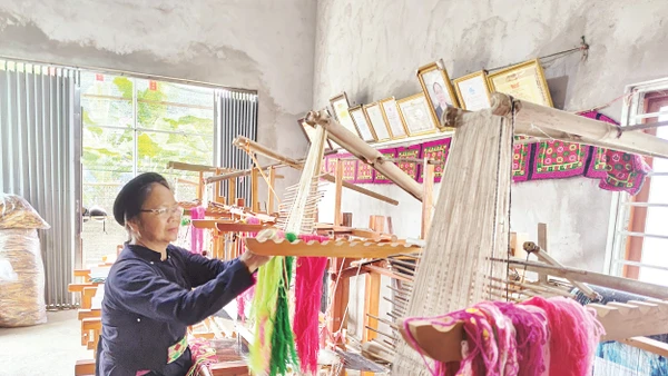 Nghệ nhân Nông Thị Thược thực hành kỹ thuật dệt thổ cẩm. Ảnh: Văn Học 