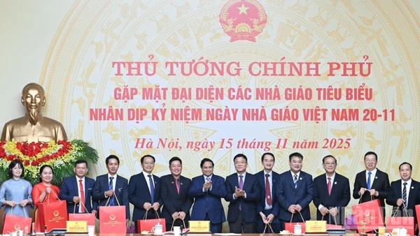 Thủ tướng Chính phủ Phạm Minh Chính tặng quà chúc mừng các giáo viên tiêu biểu tại buổi gặp mặt. (Ảnh: TRẦN HẢI)