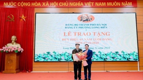 Bí thư Đảng ủy phường Long Biên trao Huy hiệu Đảng tặng đảng viên.