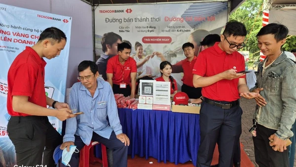 Người dân đến gian hàng của ngân hàng tham gia phiên chợ không dùng tiền mặt mở tài khoản thanh toán.