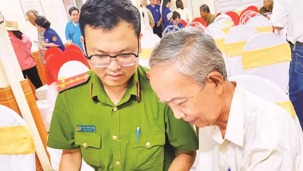 Cán bộ Công an phường Thuận Hóa hỗ trợ người cao tuổi bỏ phiếu bầu tổ trưởng qua ứng dụng trên điện thoại (Ảnh PHƯỜNG THUẬN HÓA)