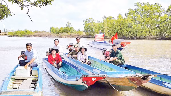 Cán bộ đến tận những căn nhà dân dựng ven sông để trao thẻ cử tri, mang lại niềm vui và sự an tâm cho người dân vùng sâu.