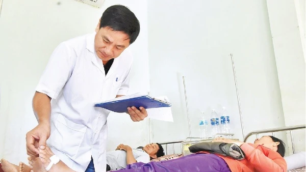 Thượng tá, bác sĩ chuyên khoa I Nguyễn Văn Tuấn, Trưởng Khoa điều trị rắn cắn khám bệnh cho bệnh nhân.