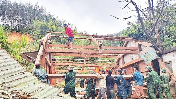 Đồn Biên phòng Anông cùng cán bộ, chiến sĩ xã Avương giúp người dân thôn Atếêp khắc phục hậu quả mưa lũ.