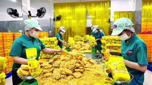 Công nhân Công ty cổ phần Lương thực thực phẩm SAFOCO làm việc trong một dây chuyền sản xuất. (Ảnh CTV)