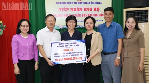 Đại diện Ủy ban Mặt trận Tổ quốc Việt Nam tỉnh Đồng Nai cùng Sở Giáo dục và đào tạo tiếp nhận bảng tượng trưng số máy vi tính, dụng cụ học tập.