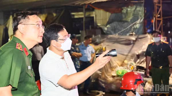 Đại tá Trần Anh Sơn, Phó Giám đốc Công an thành phố Đồng Nai (người cầm đèn pin) chỉ đạo công tác chữa cháy tại hiện trường tối 5/8. 