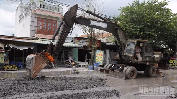Đơn vị thi công dùng xe múc sửa chữa nền đường Bưng Môn.