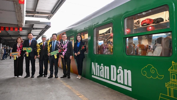 Các đại biểu tại "Chuyến tàu hạnh phúc", chuyến tàu đặc biệt có in logo của Báo Nhân Dân.