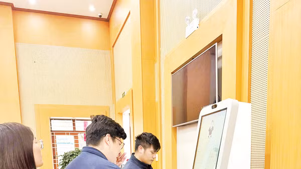 Người dân làm thủ tục hành chính qua Kiosk AI ở phường Bắc Giang. 