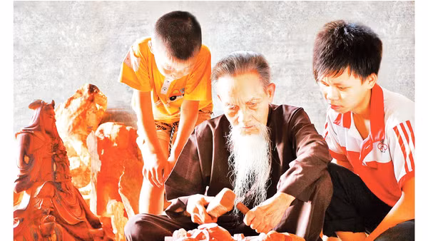 Nghệ nhân làng nghề gỗ mỹ nghệ Thiết Úng truyền nghề cho con, cháu. Ảnh: Đỗ Phong 