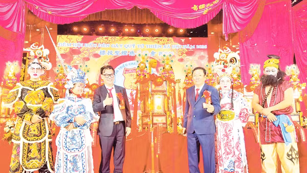 Phó Trưởng ban Thường trực Ban quản trị Hội quán Nghĩa An Trương Kính Minh (người thứ ba, từ phải sang) trao “Đèn thần Quan Thánh Đế Quân” đến người đấu giá thành công.