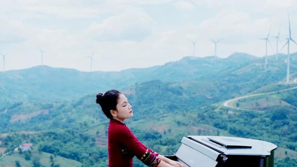 Hoa Ngọc Hà trong một chương trình ghi hình mới đây với trang phục áo dài chất liệu thổ cẩm của đồng bào Bru-Vân Kiều cùng cây đàn piano, tại quê nhà Khe Sanh. (Ảnh TRẦN TIẾN ĐẠT)