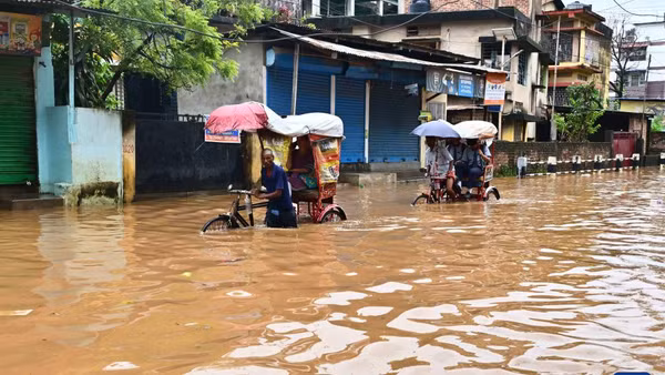 Người dân di chuyển qua vùng nước lũ sau đợt mưa lớn vào năm ngoái thành phố Guwahati, bang Assam, đông bắc Ấn Độ. (Ảnh: THX)