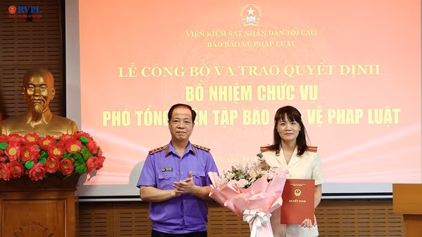  Đồng chí Trần Hải Quân, Phó Viện trưởng VKSND tối cao trao quyết định và tặng hoa chúc mừng đồng chí Hồ Thị Kim Thoan được bổ nhiệm giữ chức vụ Phó Tổng Biên tập Báo Bảo vệ pháp luật.