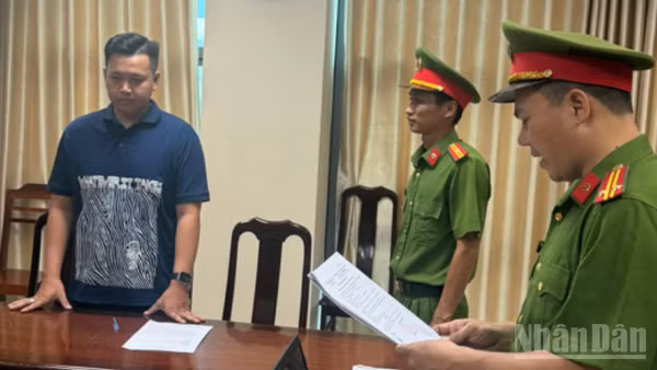 Đại diện Cơ quan Cảnh sát điều tra tống đạt các quyết định tố tụng đối với Huỳnh Thanh Hiển, chủ cửa hàng Thanh Hiển Luxury. (Ảnh: CÔNG BẰNG)