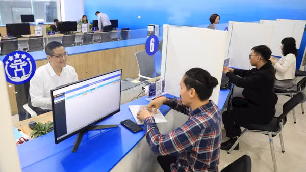Hỗ trợ người dân giải quyết thủ tục hành chính trực tuyến tại Trung tâm Phục vụ hành chính công chi nhánh Tây Hồ. (Ảnh: QUANG PHONG)