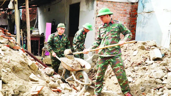 Cán bộ, chiến sĩ Trường Quân sự (Quân đoàn 34, tỉnh Gia Lai) hỗ trợ sửa chữa, xây dựng nhà cửa cho người dân sau bão lũ tại phường Ngô Mây.