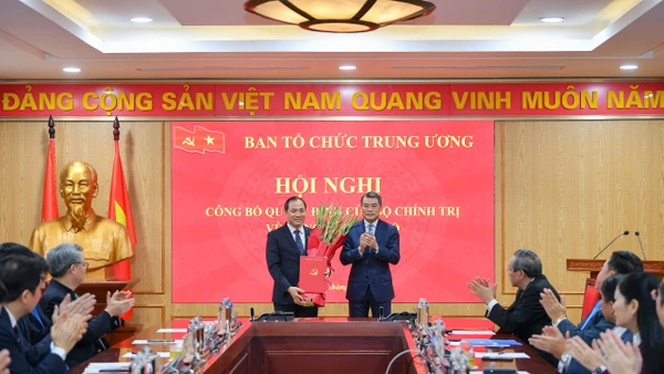 Đồng chí Lê Minh Hưng, Ủy viên Bộ Chính trị, Bí thư Trung ương Đảng, Trưởng Ban Tổ chức Trung ương trao quyết định, tặng hoa chúc mừng đồng chí Hoàng Trung Dũng (Ảnh: Thế Đại)