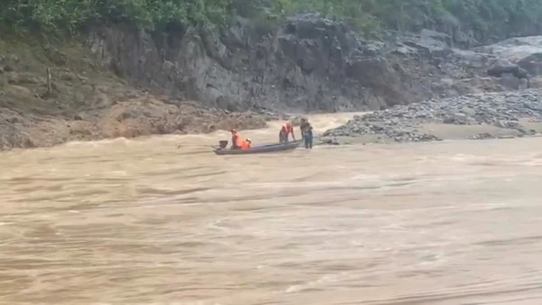 Lực lượng chức năng sử dụng xuồng máy tiếp cận khu vực hai người dân mắc kẹt, đưa họ về bờ. (Ảnh: địa phương cung cấp)