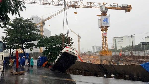 Vụ sụt lún cuốn theo hai chiếc xe ô-tô đang đậu trên vỉa hè rơi xuống hố sâu.