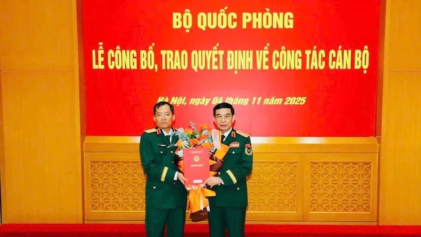 Thừa ủy quyền của Chủ tịch nước, thay mặt Quân ủy Trung ương, Bộ Quốc phòng, Đại tướng Phan Văn Giang trao Quyết định, tặng hoa chúc mừng Thiếu tướng Lương Đình Chung. (Ảnh: Quân khu 5 cung cấp)