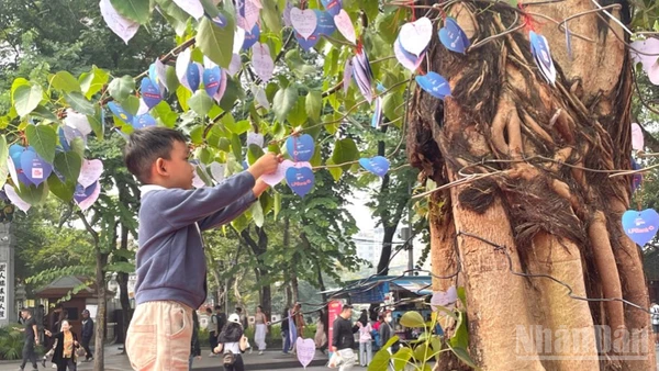 Em bé gửi gắm điều ước lên Cây Hạnh phúc. 