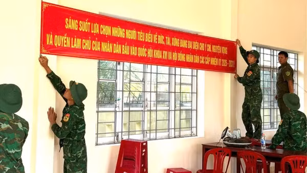 Cán bộ, chiến sĩ Đồn Biên phòng Xuân Hòa treo băng rôn tuyên truyền, hoàn thiện công tác trang trí tại khu vực bỏ phiếu trên địa bàn xã Xuân Cảnh.