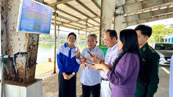 Ngư dân quét mã QR “Bảng mã QR phổ biến, tuyên truyền các quy định về phòng, chống IUU” tại cảng cá Tiên Châu.