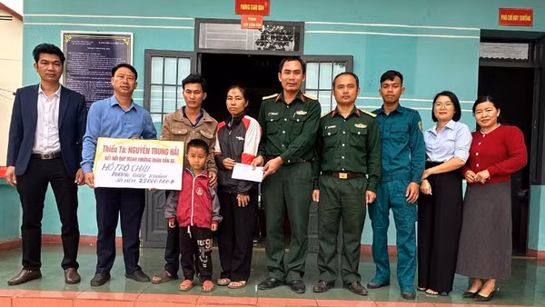 Thiếu tá Quân nhân chuyên nghiệp Nguyễn Trung Hải (thứ 5 từ phải sang), nhân viên Quân lực, Ban Chỉ huy Quân sự xã Ia Rvê cùng lãnh đạo xã Ea Kiết trao tiền các nhà hảo tâm hỗ trợ cháu Dương Quốc Khánh.