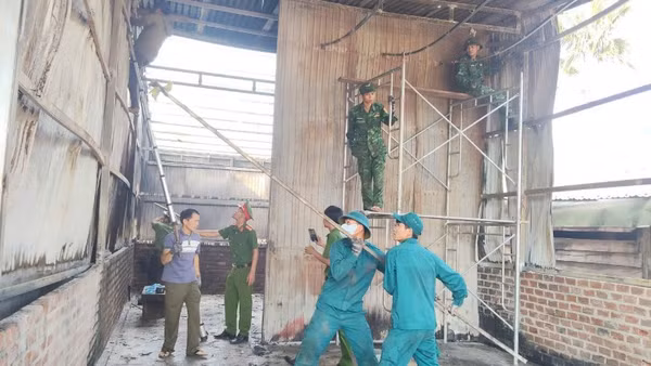 Các lực lượng giúp gia đình anh Dũng dựng lại nhà ở tạm.