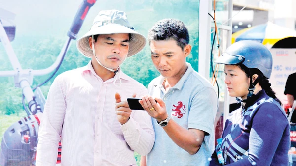 Người nông dân tìm hiểu các ứng dụng của điện thoại thông minh để phục vụ cho sản xuất. Ảnh: Hải Nam