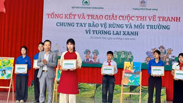 Ông Trần Xuân Tâm, Phó Giám giám đốc Quỹ Bảo vệ và Phát triển rừng tỉnh Điện Biên, trao giải Nhất cuộc thi cho em Mai Thùy Chi, lớp 8C1 Trường Trung học cơ sở Thanh Luông.