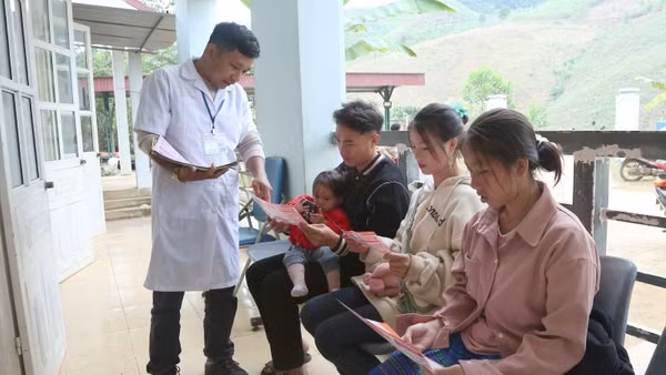 Cán bộ Trạm Y tế Tân Xuân, xã Xuân Nha, phát tờ rơi tuyên truyền về giảm thiểu mất cân bằng giới tính khi sinh.