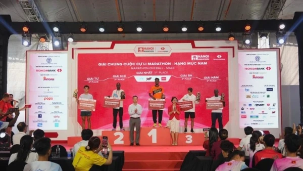 Bà Lê Thị Hoàng Yến, Phó Cục trưởng Cục TDTT và ông Phạm Xuân Tài, Phó Giám đốc Sở Văn hóa và Thể thao Thành phố Hà Nội trao giải cho các VĐV xuất sắc đường đua marathon nam.
