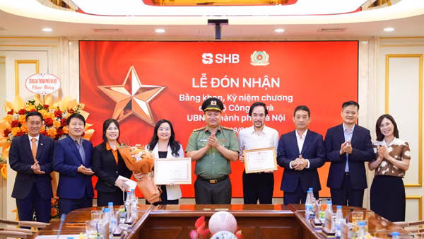 Đại tá Nguyễn Tiến Đạt, Phó Giám đốc Công an TP Hà Nội trao bằng khen và công nhận tới đại diện lãnh đạo SHB.