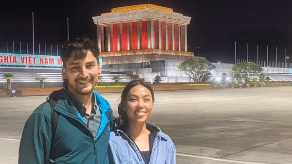Anh Jack Warren và chị Annie Tao, du khách đến từ Mỹ, chụp ảnh lưu niệm bên Lăng Bác, tháng 1/2026. (Ảnh NVCC)