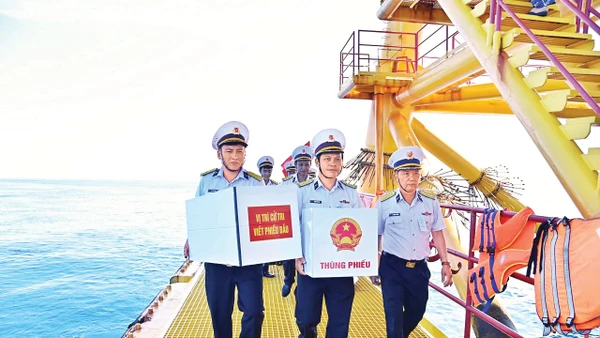 Tổ Bầu cử sớm của Vùng 2 Hải quân (khu vực bầu cử số 5, xã Long Sơn, Thành phố Hồ Chí Minh) mang thùng phiếu và vật tư trang bị lên nhà giàn DK1/9. (Ảnh Văn Đường) 