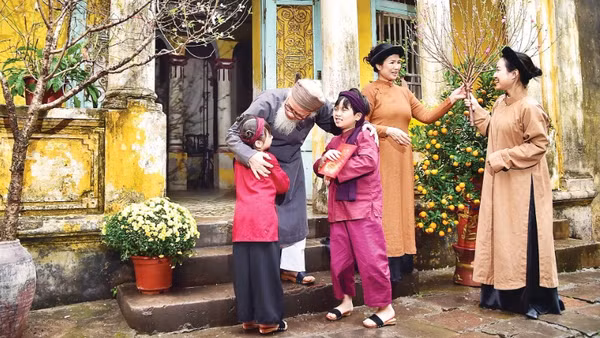 Nụ cười sum vầy của gia đình miền bắc với cành đào xuân là biểu tượng thiêng liêng của sự gắn kết và ấm áp trong ngày Tết cổ truyền.