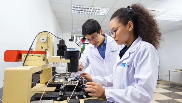 Tiến sĩ Nguyễn Viết Hương (bên trái) thực hành thí nghiệm. (Ảnh NVCC)