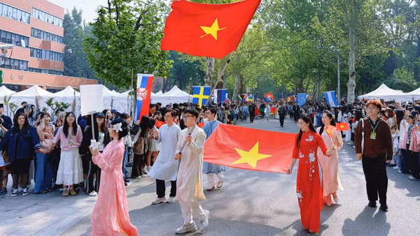 Lưu học sinh Việt Nam rước quốc kỳ tại lễ hội văn hóa.