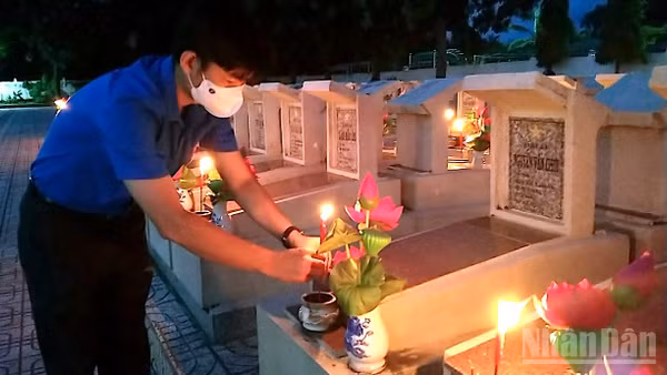 Đoàn viên Cà Mau thắp nến tri ân tại Nghĩa trang liệt sĩ tỉnh. (Ảnh HỮU TÙNG)