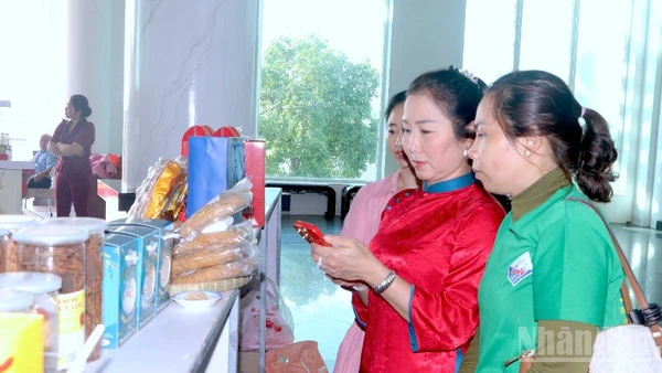 Khách hàng tham quan trưng bày sản phẩm OCOP bên lề hội nghị và trải nghiệm quét mã truy xuất nguồn gốc sản phẩm được in trên bao bì.