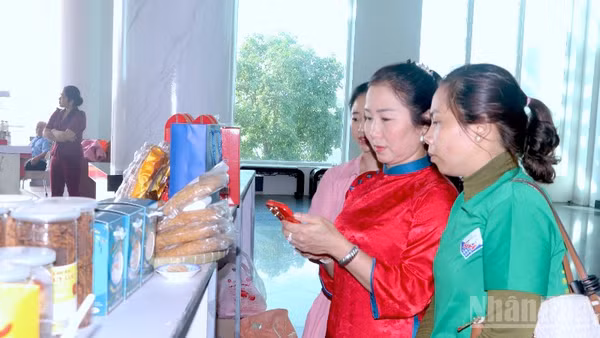 Khách hàng tham quan trưng bày sản phẩm OCOP bên lề hội nghị và trải nghiệm quét mã truy xuất nguồn gốc sản phẩm được in trên bao bì.