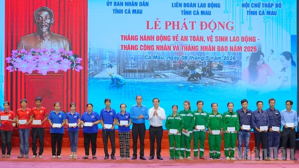 Đại diện lãnh đạo tỉnh Cà Mau và Liên đoàn Lao động tỉnh (đứng giữa) trao quà tặng cho công nhân, công đoàn viên, người lao động tại lễ phát động.