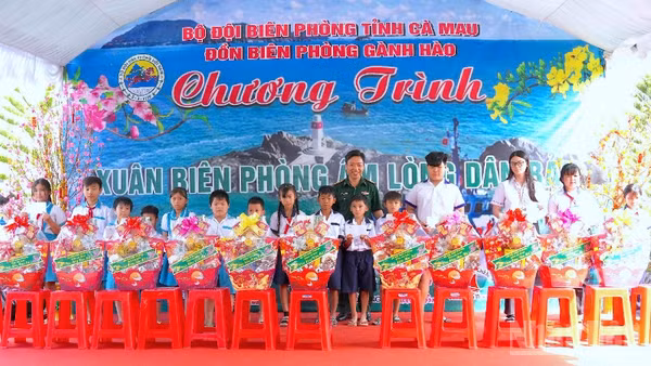 Đại tá Phạm Minh Giang, Chính ủy Bộ đội Biên phòng Cà Mau (đứng giữa) trao quà tặng học sinh nghèo vùng ven biển Gành Hào.