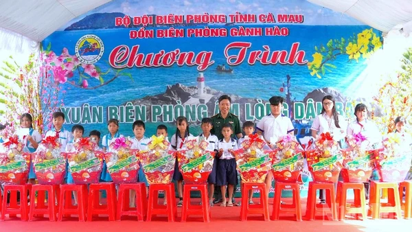 Đại tá Phạm Minh Giang, Chính ủy Bộ đội Biên phòng Cà Mau (đứng giữa) trao quà tặng học sinh nghèo vùng ven biển Gành Hào.