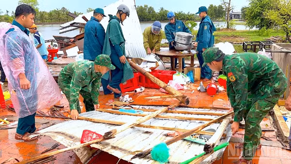 Cán bộ, chiến sĩ Đồn biên phòng Khánh Tiến chung tay cùng địa phương giúp người dân khắc phục hậu quả sau thiên tai.