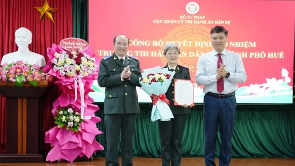 Cục trưởng Cục Quản lý Thi hành án dân sự Nguyễn Thắng Lợi và Trưởng Ban Tổ chức Thành ủy Huế Phan Xuân Toàn trao quyết định, tặng hoa chúc mừng bà Phan Thùy Dương.