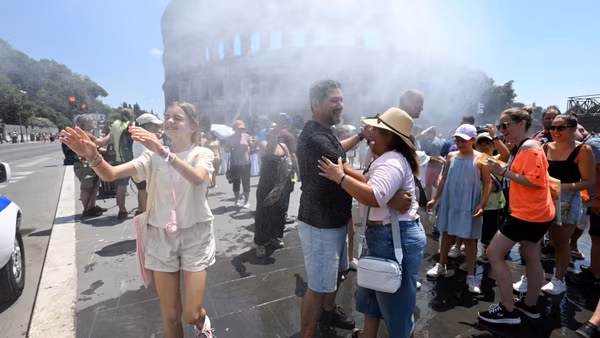 Người dân làm mát gần thiết bị phun sương tại Rome, Italy ngày 26/6/2026. (Ảnh: THX/TTXVN)